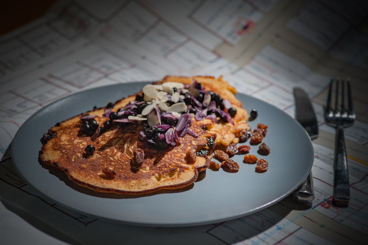 Tasty paleo pancake topped with almonds and raisins, ideal for healthy breakfasts.